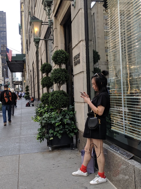 A shopper leaning against the Bergdorf Goodman window